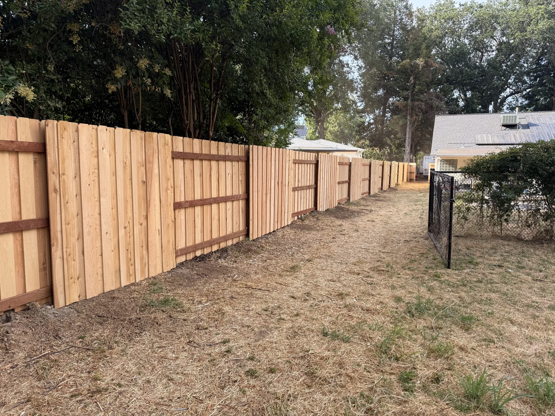 Long cedar privacy fence line in backyard installed by Bowman Built